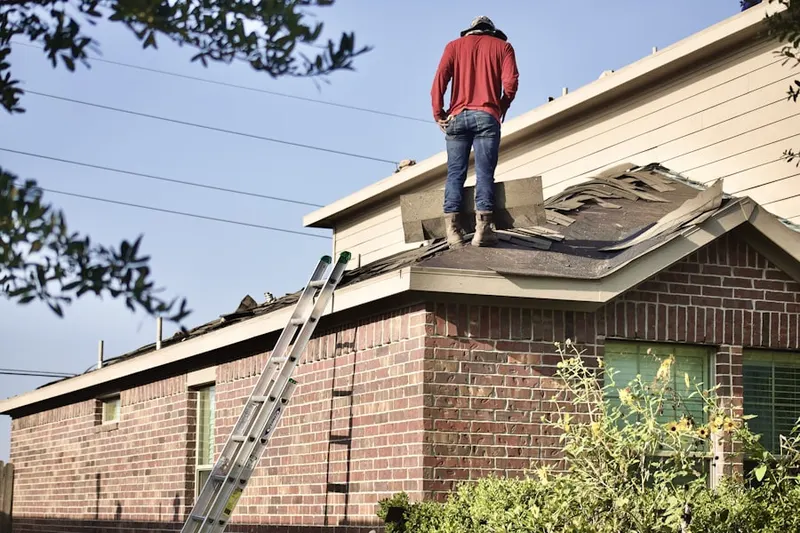 Professional roofer working on a residential roof in Stafford